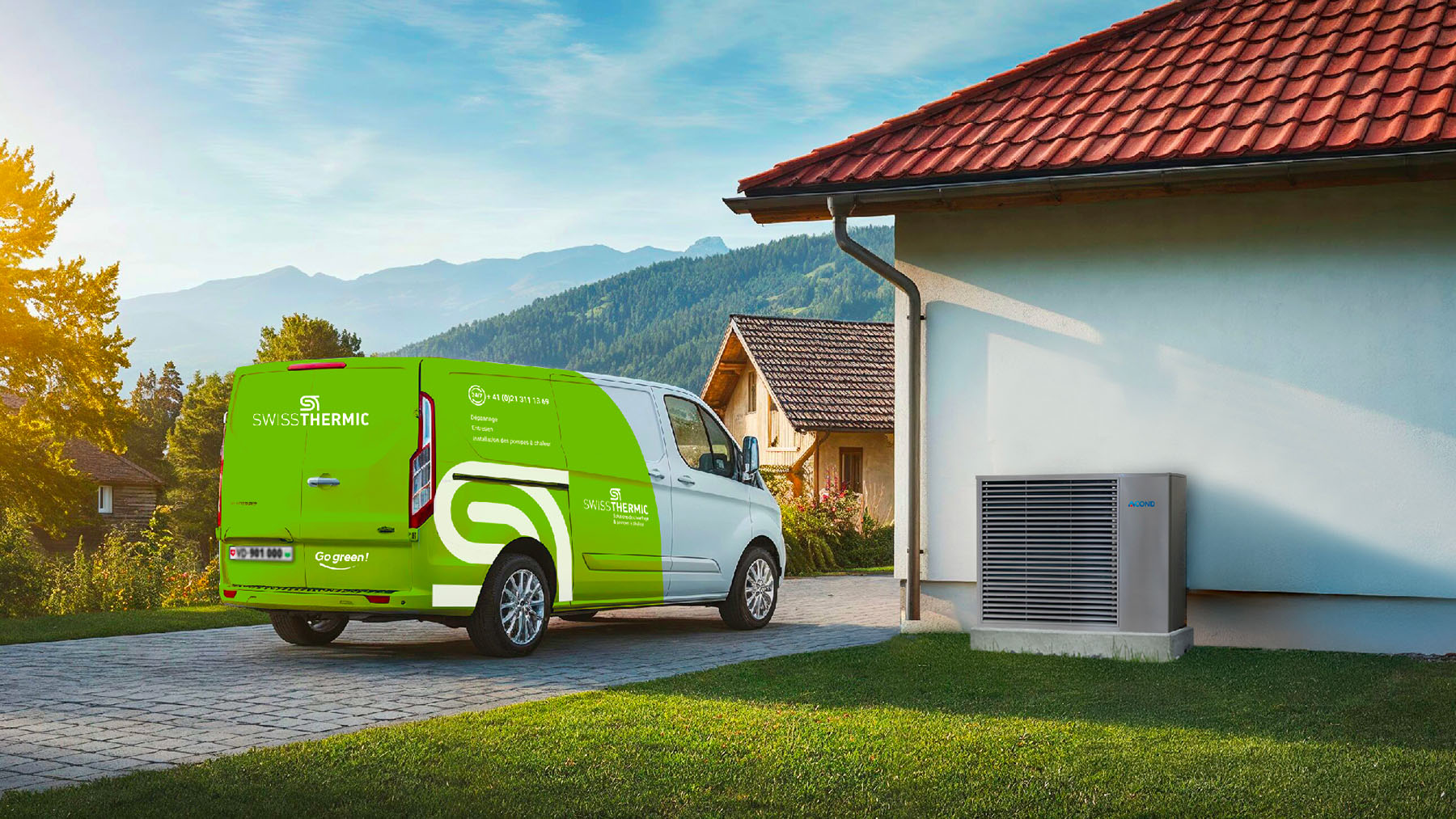 Camionnette Swissthermic verte devant une maison avec pompe à chaleur et montagnes en arrière-plan